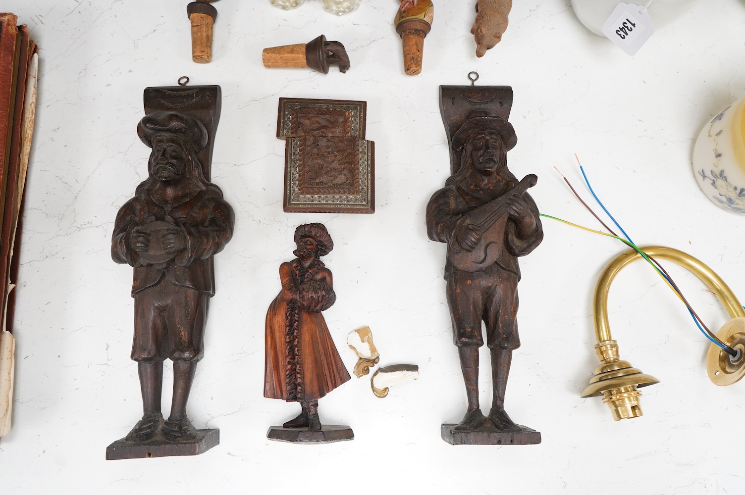 A collection of Black Forest wooden figurative carvings to include a pair of corbels in the form of musicians and a carved bear bottle stopper, largest 32cm high. Condition - mostly fair